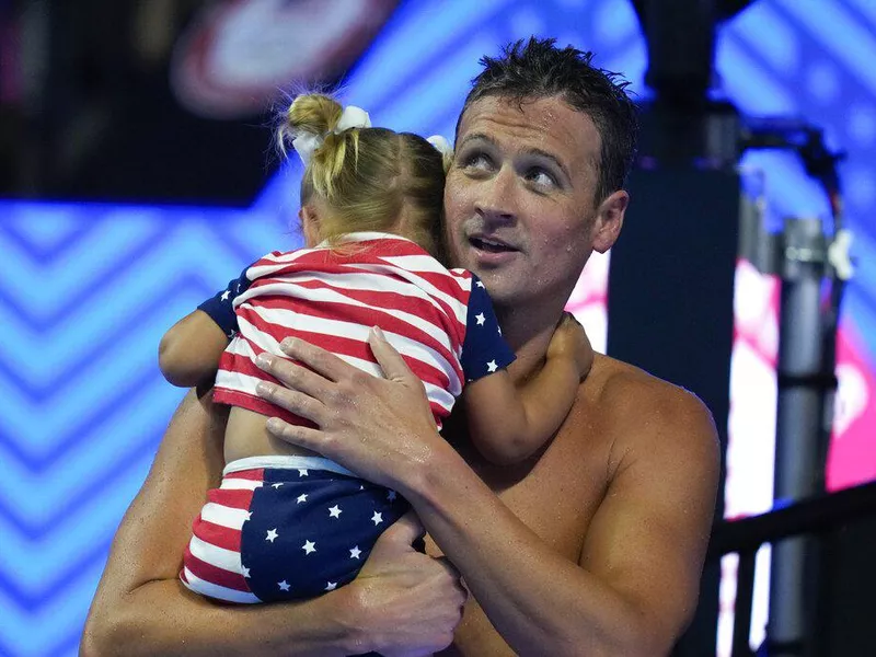 Ryan Lochte holds his daughter after his heat in the men's 200 Individual Medley during wave 2 of the U.S. Olympic Swim Trials